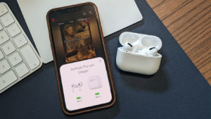 Das Foto zeigt ein iPhone 12 Pro mit geöffneter Netflix App. Daneben liegen die Airpods Pro im geöffneten Ladecase.
